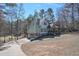 Side view of this beautiful two-story home with a two-car garage and welcoming front porch surrounded by mature trees at 9001 E Carroll Rd, Winston, GA 30187