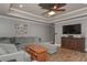 Open-concept living room with wood-look tile flooring, gray walls, and large sectional sofa at 9001 E Carroll Rd, Winston, GA 30187
