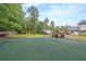 Green backyard featuring chairs for relaxation, surrounded by trees, and a fence, creating a private retreat at 110 W Putnam Ferry Rd, Woodstock, GA 30189