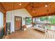 Inviting wooden deck featuring a porch swing, ceiling fan, and welcoming entryway at 110 W Putnam Ferry Rd, Woodstock, GA 30189
