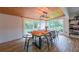 Bright dining room features wood look floors, large windows, and a rustic wood table at 110 W Putnam Ferry Rd, Woodstock, GA 30189
