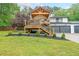 Charming home exterior featuring a wood deck, landscaped yard, and attached two-car garage at 110 W Putnam Ferry Rd, Woodstock, GA 30189