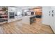 Bright kitchen with stainless appliances, white cabinetry, a large island with quartz countertops and an open concept layout at 110 W Putnam Ferry Rd, Woodstock, GA 30189