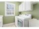 Well-lit laundry room with white cabinets and modern washer and dryer at 3505 Belridge Ln, Smyrna, GA 30080