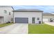 Back exterior of home with grey siding, a gray garage door, concrete driveway and a small yard at 3658 Madison St, College Park, GA 30337