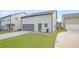Backyard view of the home with grey vinyl siding, garage, driveway, and small yard at 3658 Madison St, College Park, GA 30337