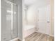 Bright bathroom with a glass-enclosed shower and a soaking tub under a window at 3658 Madison St, College Park, GA 30337