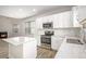 Bright kitchen features white cabinets, stainless steel appliances, and a large island for ample counter space at 3658 Madison St, College Park, GA 30337