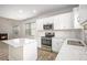 Well-lit kitchen features white cabinets, subway tile backsplash, stainless steel appliances and speckled quartz countertops at 3658 Madison St, College Park, GA 30337