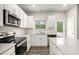 Modern kitchen boasts stainless steel appliances, white cabinets, and speckled quartz countertops at 3658 Madison St, College Park, GA 30337