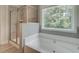 Bathroom featuring a glass shower enclosure and a soaking tub next to a window at 4504 Eastbrook Pl, Snellville, GA 30039