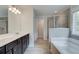 Bright bathroom features a double vanity, large tub, and glass shower with tile surround at 4554 Eastbrook Pl, Snellville, GA 30039