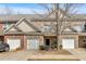 A brick townhome featuring attached garages, a small front yard, and mature trees at 2555 Flat Shoals Road Rd # 1104, College Park, GA 30349