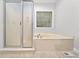 Bright bathroom featuring corner tub, shower, and tiled floor at 4544 Dorsett Shoals Run, Douglasville, GA 30135