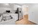 Well-lit kitchen with stainless steel refrigerator, white cabinets, and hardwood floors at 4544 Dorsett Shoals Run, Douglasville, GA 30135
