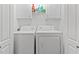 Laundry room featuring a front-load washer, dryer, and storage cabinets at 4544 Dorsett Shoals Run, Douglasville, GA 30135