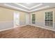 Main bedroom featuring tray ceilings, hardwood floors, and lots of natural light at 4544 Dorsett Shoals Run, Douglasville, GA 30135