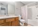 Bathroom featuring a light wood vanity, toilet, and tub with shower and a pink and white shower curtain at 752 Wood Bend Ct, Riverdale, GA 30296