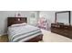 Cozy bedroom with a dark wood bed frame, matching dresser with mirror, and a bright window at 752 Wood Bend Ct, Riverdale, GA 30296