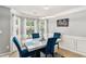 Bright dining room featuring a marble table, blue chairs, and three large windows offering great natural light at 752 Wood Bend Ct, Riverdale, GA 30296