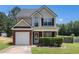Charming two-story home featuring a brick facade, well-manicured lawn and attached garage at 752 Wood Bend Ct, Riverdale, GA 30296