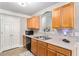Galley kitchen featuring wood cabinets, laminate countertops, stainless sink, and a pantry door at 752 Wood Bend Ct, Riverdale, GA 30296