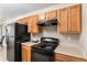 Kitchen with black appliances, wood cabinets, double door pantry and laminate countertops at 752 Wood Bend Ct, Riverdale, GA 30296