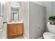 Small bathroom with a wood vanity, framed mirror, white toilet, and stylish décor at 752 Wood Bend Ct, Riverdale, GA 30296