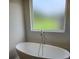 Freestanding tub with modern fixtures below a frosted window offers a bright and private space at 1669 Fuma Leaf Way, Mcdonough, GA 30253
