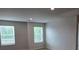 A spacious bedroom featuring natural walls, plush carpeting, and large windows for lots of natural light at 1669 Fuma Leaf Way, Mcdonough, GA 30253
