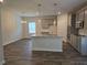 Open kitchen boasts an island, stainless appliances, and granite countertops, flowing into the dining area at 1669 Fuma Leaf Way, Mcdonough, GA 30253