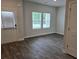 Cozy living room with hardwood floors, two windows, and a white door with blinds at 1669 Fuma Leaf Way, Mcdonough, GA 30253