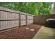 Enclosed backyard with mulch and a stone path features a wooden fence, offering privacy at 1771 Defoor Nw Ave # D, Atlanta, GA 30318