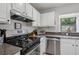 Clean kitchen featuring granite counters, stainless steel appliances, and white cabinetry at 1771 Defoor Nw Ave # D, Atlanta, GA 30318
