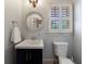 Powder room featuring a white vanity, round mirror, and white toilet and wainscoting at 2668 Jefferson Ter, East Point, GA 30344