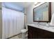 Bathroom features a dark vanity, framed mirror, shower with a curtain and tiled walls at 2668 Jefferson Ter, East Point, GA 30344