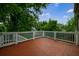 Deck with tiled flooring and white railings, surrounded by lush trees at 2668 Jefferson Ter, East Point, GA 30344