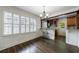 Light-filled dining space with dark wood floors, and views of the kitchen through an open framed space at 2668 Jefferson Ter, East Point, GA 30344