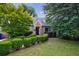 Well-kept lawn with neatly trimmed hedges and mature trees surrounding a cozy, light-green house at 2668 Jefferson Ter, East Point, GA 30344