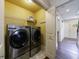 Laundry room area with yellow walls, front-loading washer and dryer at 2668 Jefferson Ter, East Point, GA 30344