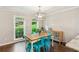 Charming dining room with hardwood floors, two windows, and a rustic table with bright teal chairs at 2696 Chancellor Way, Duluth, GA 30096