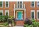 Close-up of the home's entrance featuring a bright blue door, white trim, and manicured landscaping at 2696 Chancellor Way, Duluth, GA 30096