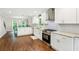Updated kitchen with white cabinets, stainless steel appliances, granite counters, and hardwood floors at 2696 Chancellor Way, Duluth, GA 30096