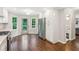 Open-concept kitchen featuring stainless steel refrigerator, hardwood floors, and access to the backyard at 2696 Chancellor Way, Duluth, GA 30096