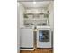 Laundry room with washer, dryer, and shelving for ample storage at 2696 Chancellor Way, Duluth, GA 30096