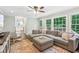 Comfortable living room with a large sectional sofa, hardwood floors, and expansive windows with backyard views at 2696 Chancellor Way, Duluth, GA 30096