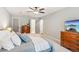 Bedroom featuring a ceiling fan, a dresser, and two closet doors to the main ensuite bathroom at 2696 Chancellor Way, Duluth, GA 30096