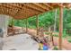 Covered patio area with exposed beams, wood storage, and a glimpse of the green yard at 2696 Chancellor Way, Duluth, GA 30096
