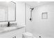Modern bathroom featuring white-tiled walls, marble countertops, and sleek black hardware at 2873 Bob White Sw Dr, Atlanta, GA 30311