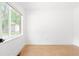 Sunlit bedroom featuring hardwood floors, white walls, and a large window at 2873 Bob White Sw Dr, Atlanta, GA 30311